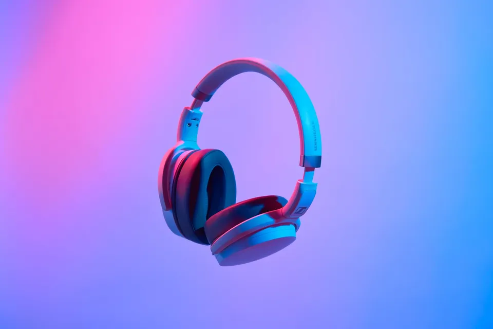 Headphones product photo before background removal, shot against a coloured studio backdrop