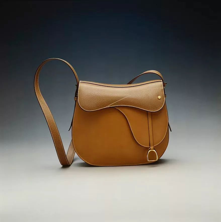 Product photo of a leather bag before background removal, sitting on a studio surface